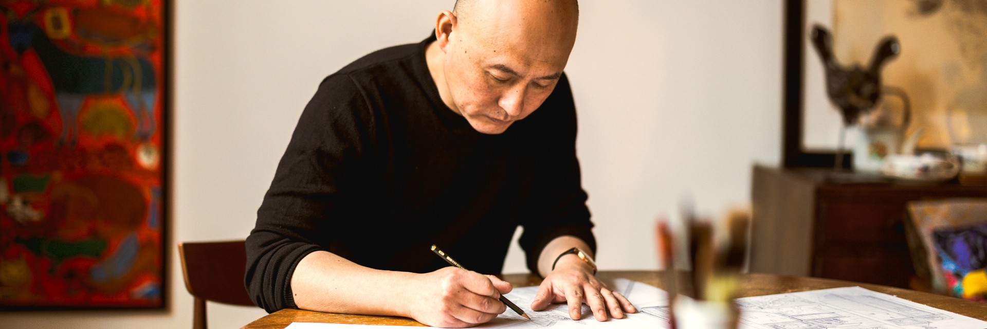  Illustrator Shan Jiang drawing at a table
