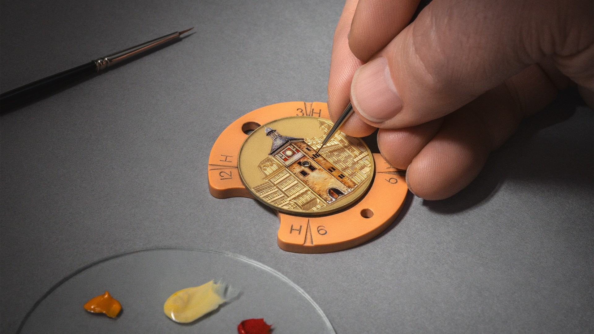 Hand painting a miniature building on a watch dial with fine detail