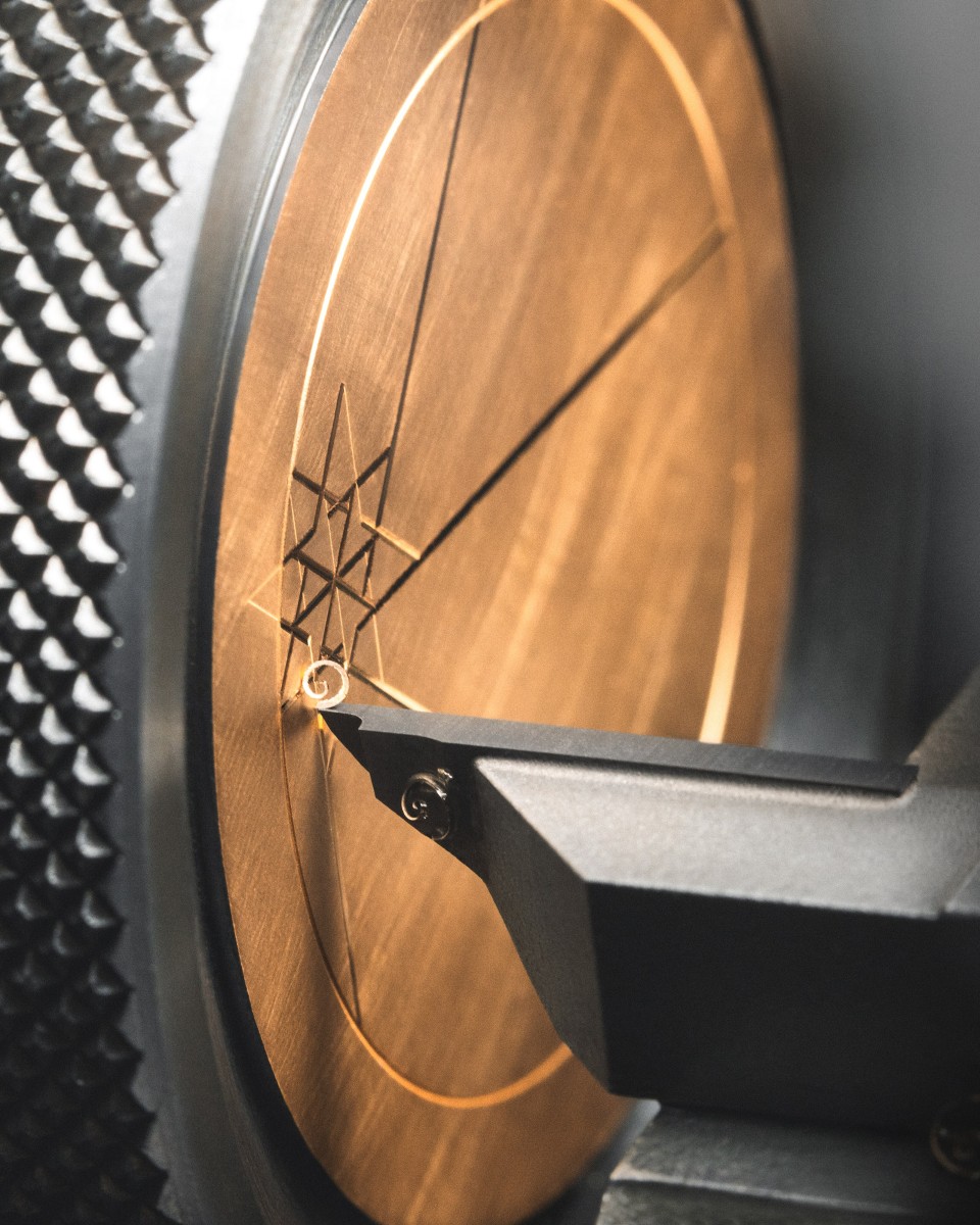   Star-shaped motif being engraved into wooden disc.