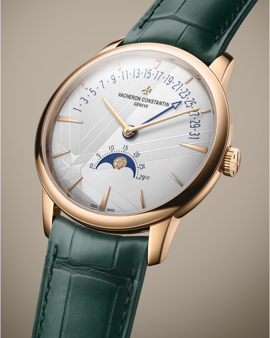 A luxury wristwatch with a green leather strap, gold case, day-of-month markers, and a moon phase indicator.