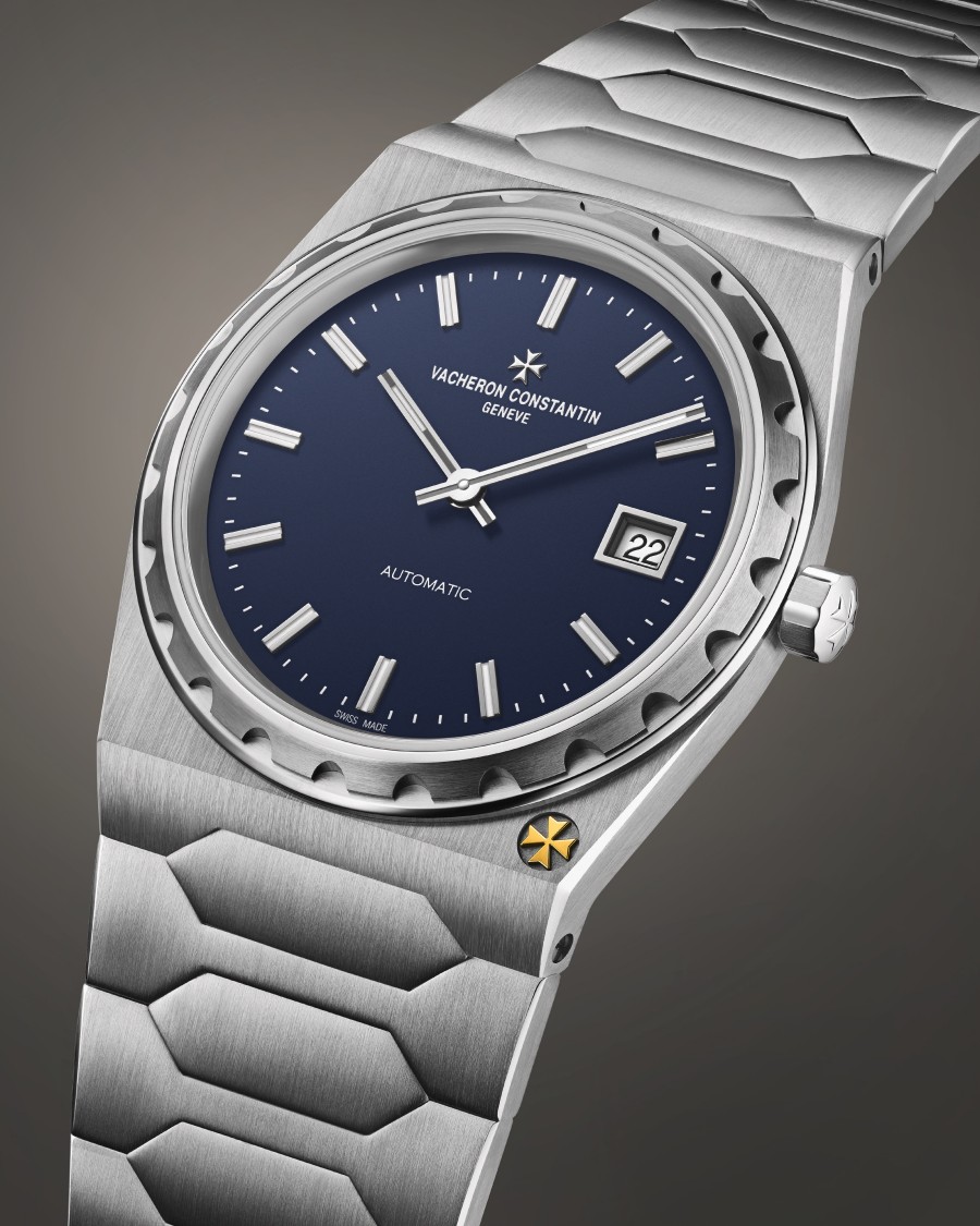 A luxury timepiece with a metallic bracelet, a blue dial, and a date display.