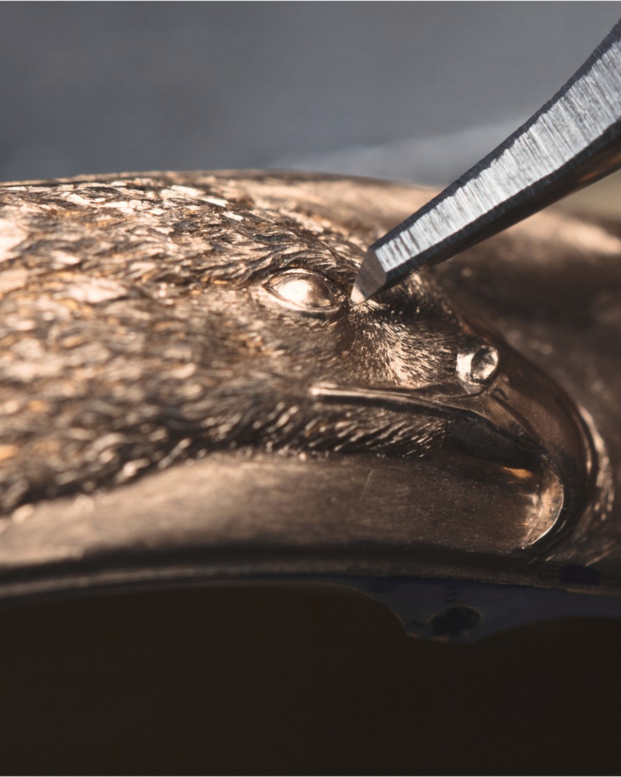  Hand engraving a detailed eagle head into a metal surface.