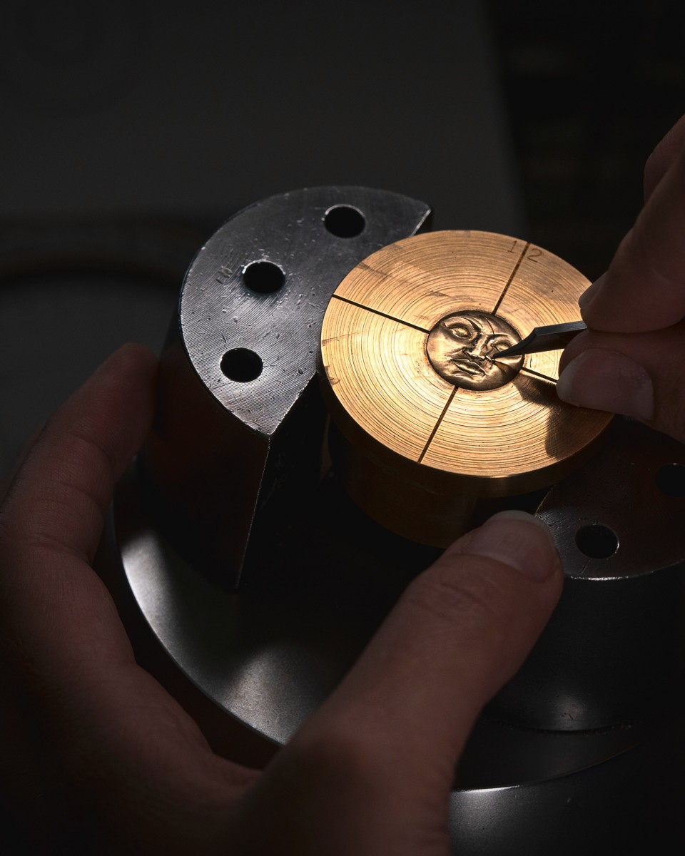 Image illustarting a face engraved on a golden object 