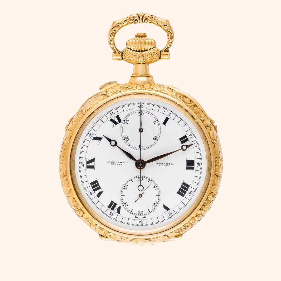 An ornate gold pocket watch with a white face, Roman numerals.