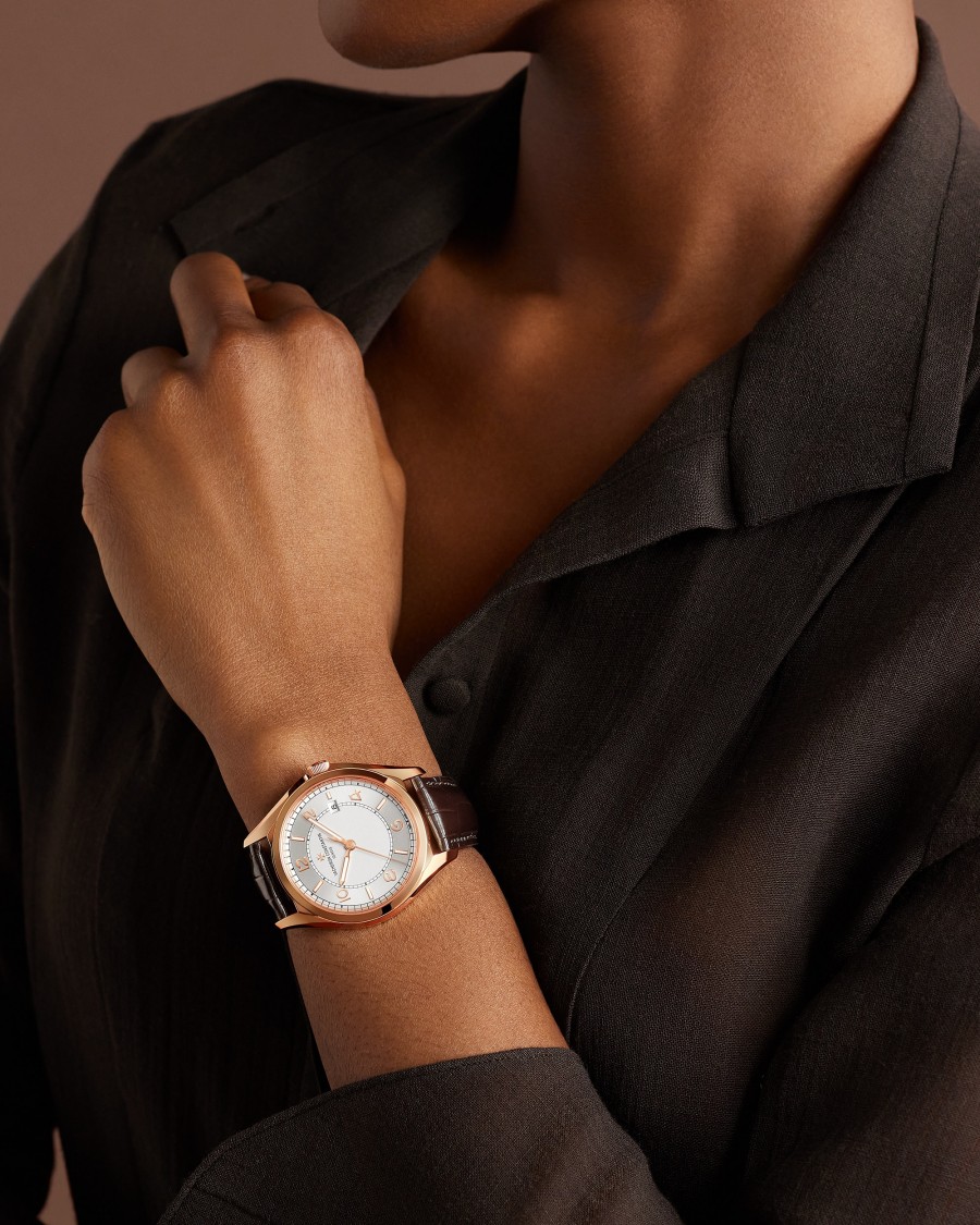  Fiftysix watch with gold case and brown leather strap.