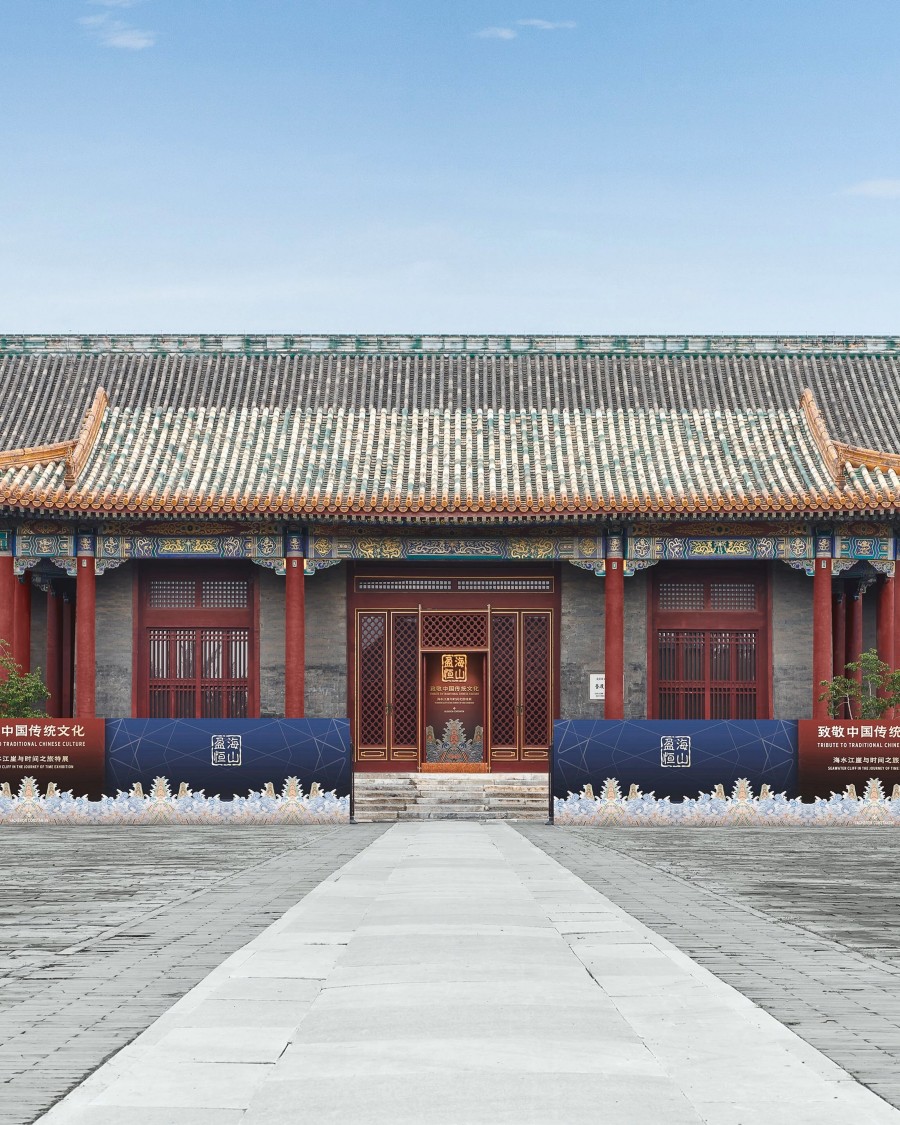 Traditional Chinese building with red columns and a stone path leading to the entrance.
