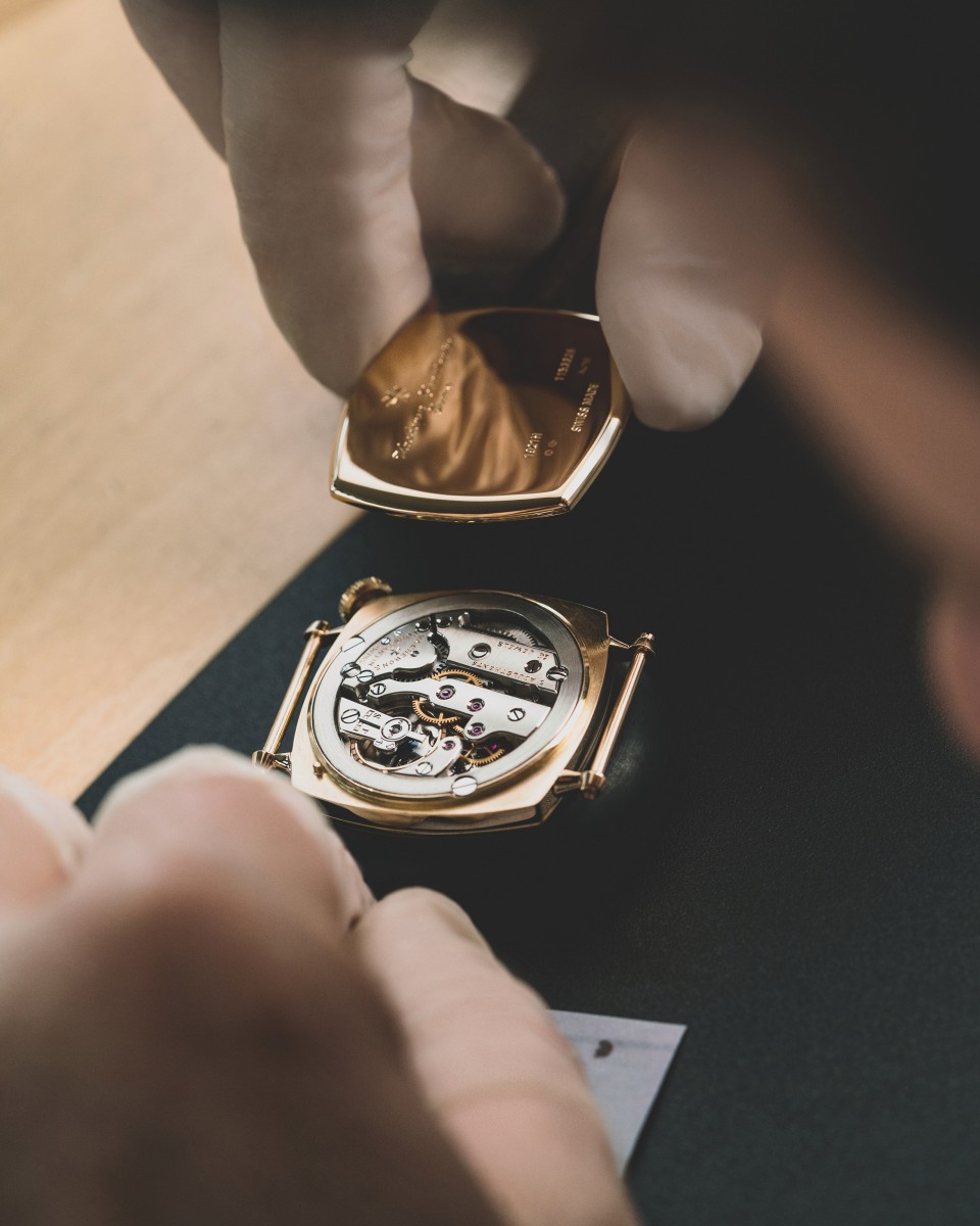 Hands setting up the elegant, golden watch