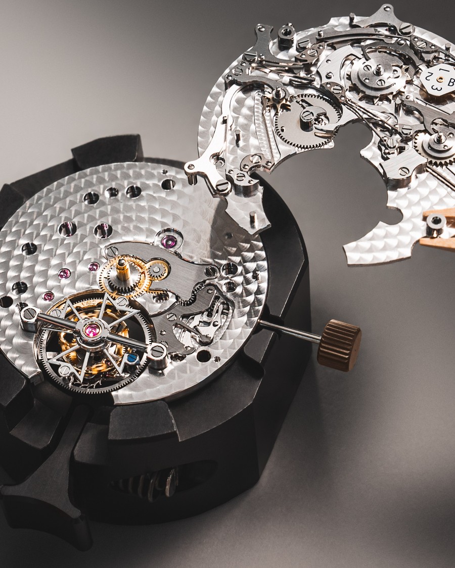 A disassembled mechanical watch movement with a visible tourbillon.