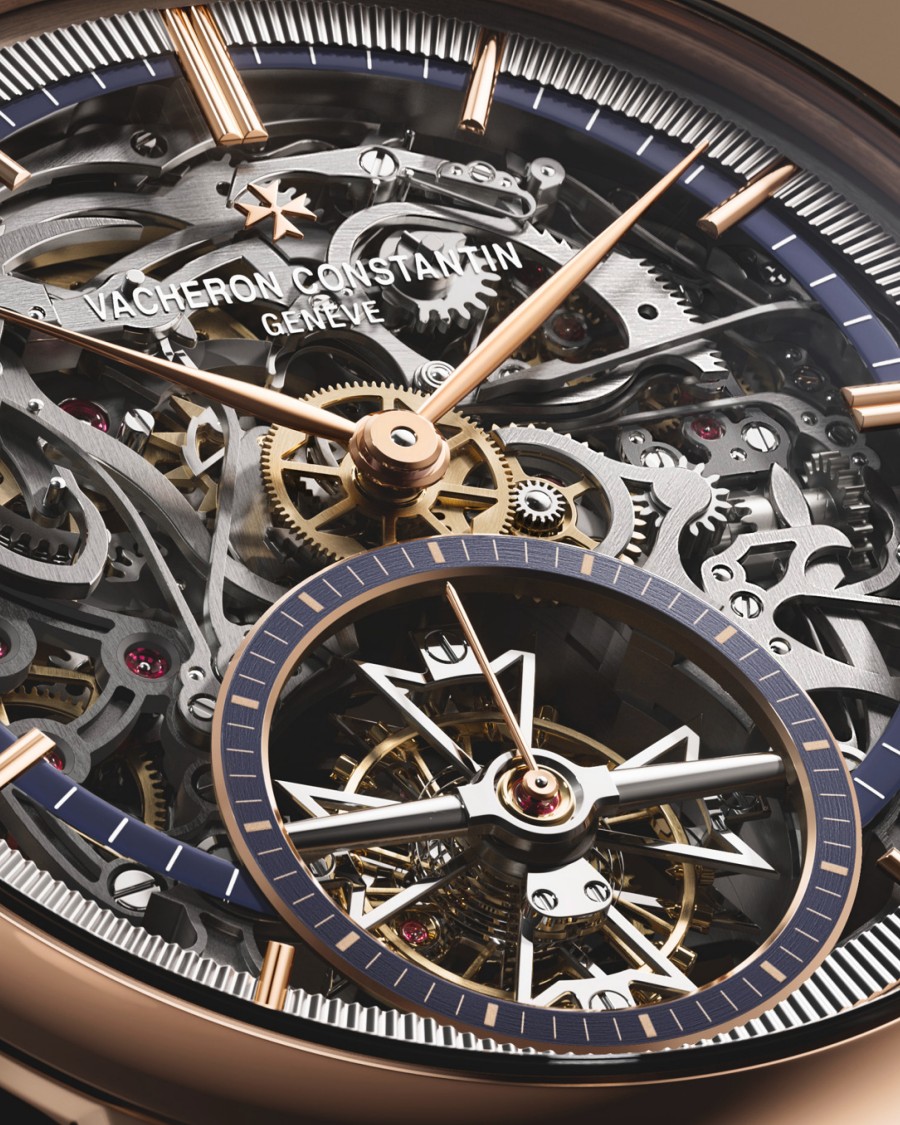 Minute Repeater Tourbillon Skeleton watch with a navy blue strap and a gold bezel on a dark brown background.