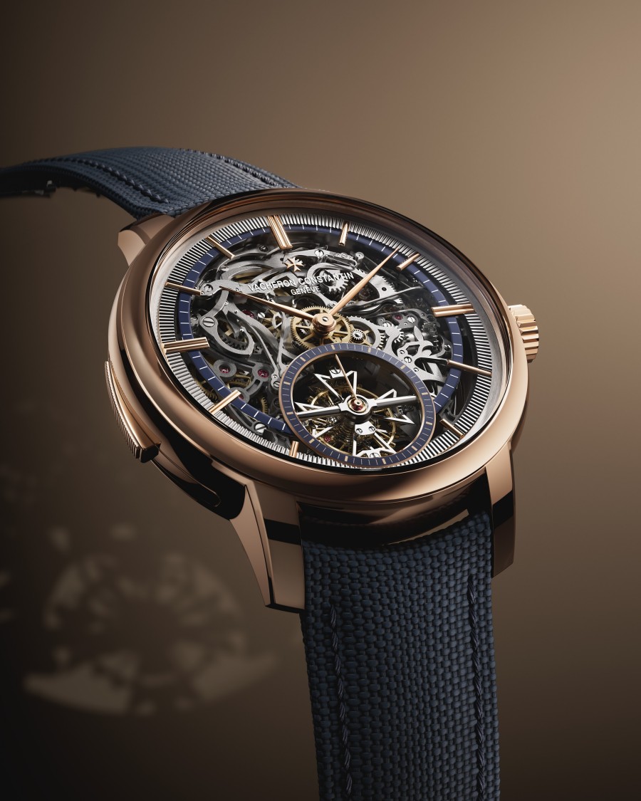 Skeleton wristwatch with dark leather strap on a dark background.