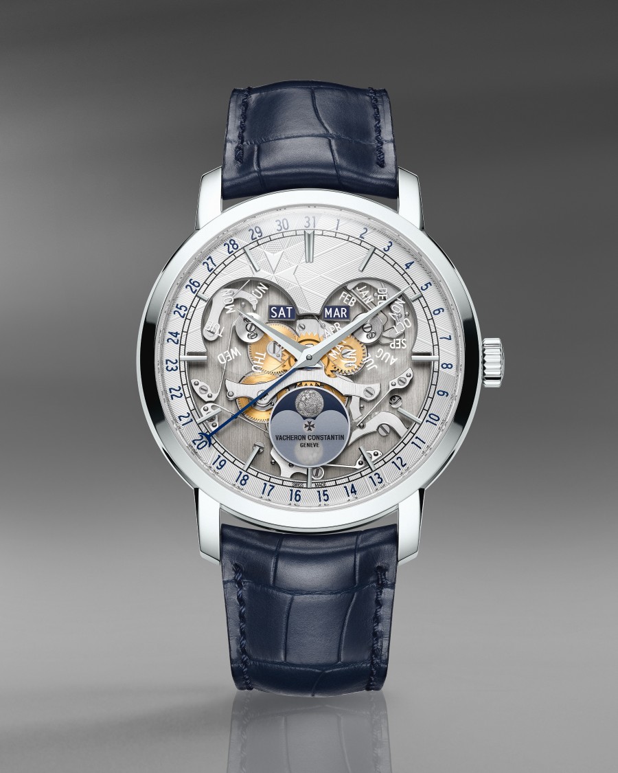 High-end timepiece with an open-worked dial, calender complications, lunar phase display, and a blue leather strap.