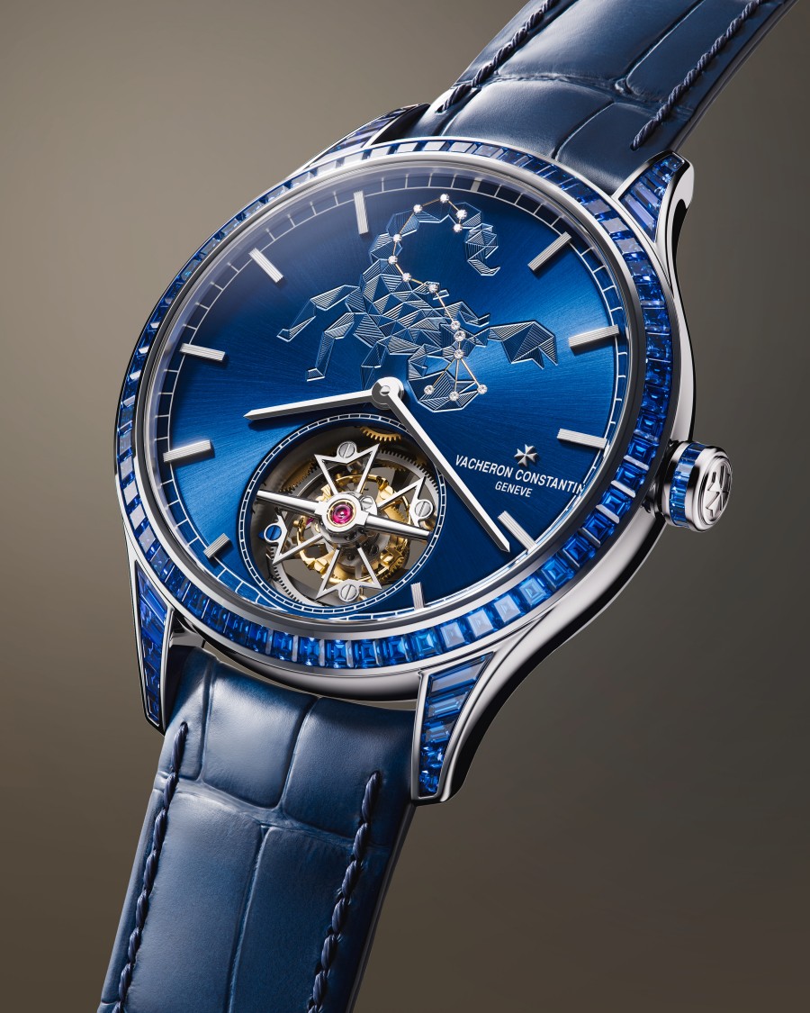 An exclusive wristwatch with a blue dial featuring a scorpion motif and a sophisticated mechanical movement visible through an open window.